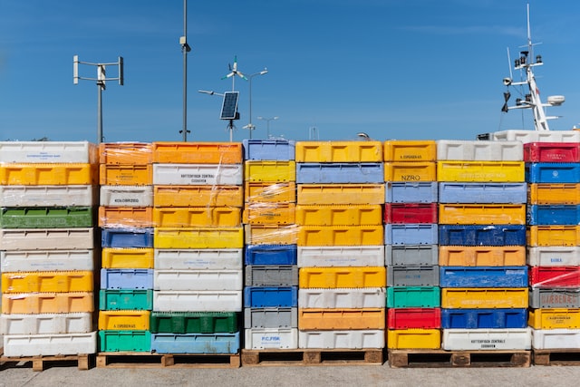 Picture of five rectangular layers of plastic containers side by side with antennas propping on the top under a clear blue sky.